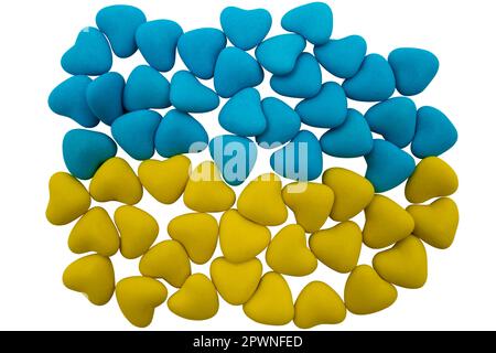 Gelbe und blaue herzförmige Süßigkeiten in Form der Nationalflagge der Ukraine, isoliert auf weißem Hintergrund. Nahaufnahme, Draufsicht Stockfoto