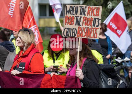 Berlin, Deutschland. 01. Mai 2023. Ein Teilnehmer hält ein Schild mit der Aufschrift „Wenn die Reichen die Armen ausrauben, heißt das Geschäft“. Am Tag der Arbeit findet eine Demonstration des Deutschen Gewerkschaftsbundes (DGB) unter dem Slogan "ungebrochene Solidarität" statt. Kredit: Hannes P. Albert/dpa/Alamy Live News Stockfoto