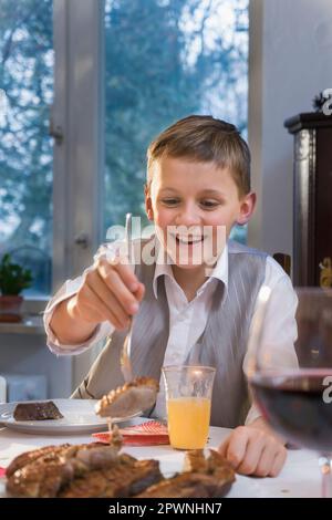 Der Junge isst zu Weihnachten Stockfoto