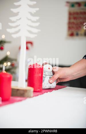 Eine Frau, die den Weihnachtstisch dekoriert Stockfoto