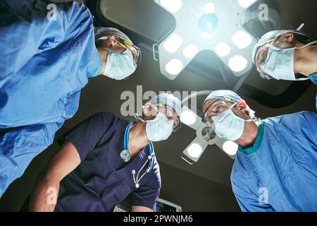 Jede Sekunde zählt. Low-Angle-Aufnahme von Chirurgen im Operationssaal. Stockfoto