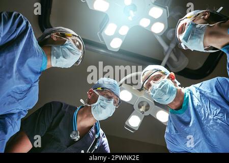 Leben retten ist ihre Spezialität. Low-Angle-Aufnahme von Chirurgen im Operationssaal. Stockfoto