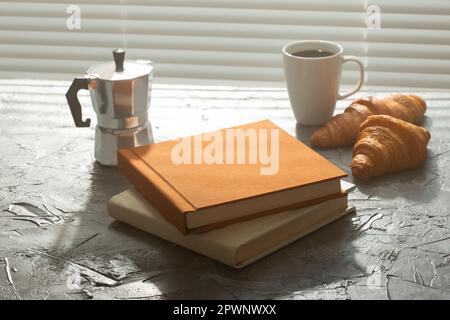 Stillleben für angenehmen Morgenkaffee türkischbecher und Croissants mit zwei Büchern auf dem Tisch. Mittagspause oder beginnen Sie den Morgen Stockfoto