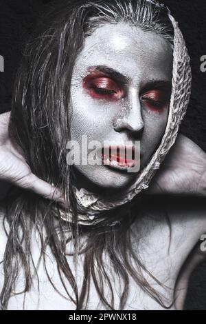 Ein Mädchen in Form von Zombies, eine Halloween-Leiche mit Blut auf seinen Lippen. Bild für einen Horrorfilm. Im Studio aufgenommene Fotos Stockfoto