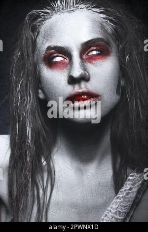 Ein Mädchen in Form von Zombies, eine Halloween-Leiche mit Blut auf seinen Lippen. Bild für einen Horrorfilm. Im Studio aufgenommene Fotos Stockfoto