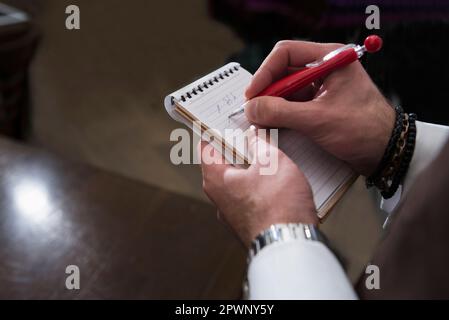 Zugeschnittenes Bild der Schreibreihenfolge des Kellners im Notizblock Stockfoto