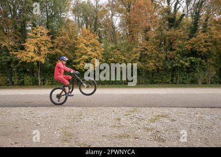 Ein Mann, der Wheelie auf dem Mountainbike macht Stockfoto