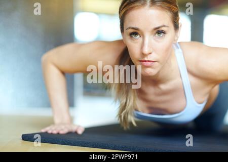 Ich mache große Fortschritte. Eine wunderschöne junge Frau, die im Fitnessstudio trainiert. Stockfoto