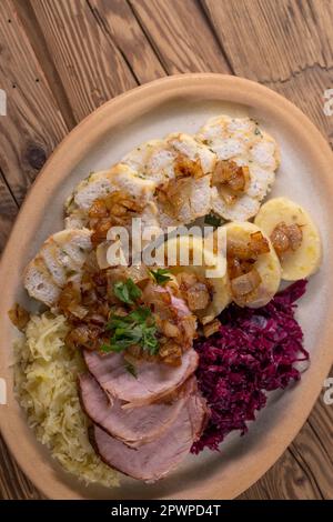 Geräuchertes Fleisch, serviert mit Rot- und Weißkohl und zwei Sorten Knödel Stockfoto