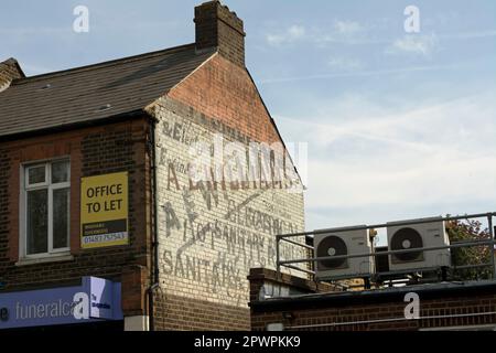 geisterschild auf einem Gebäude im Raynes Park, Südwest london, england, Werbung a.e. williams, Elektrik, Heißwasser- und Sanitäranlageningenieur Stockfoto