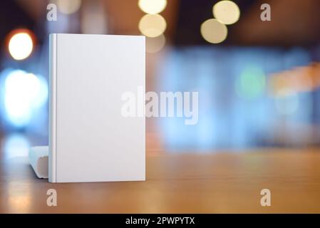 Festes Buch auf Holztisch. Vorlage zum Platzieren Ihres Designs. 3D-Rendering und Foto. Stockfoto