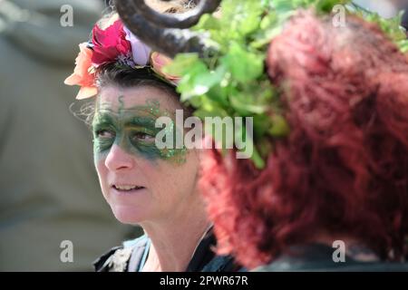 Glastonbury, Somerset, Großbritannien. 1. Mai 2023 Dekorierte Gesichter in der Menge. Die heidnischen Beltane-Feierlichkeiten finden jedes Jahr zwischen dem Frühling und dem Sommerfrühstück am 1. Mai statt. Die Leute treffen sich, ziehen sich grün an, genießen eine Parade, Musik und Tanz. Das Festival hat seine Wurzeln in den frühen gälischen Saisonfeiern und passt gut zu der neuen Altersgemeinschaft, die diese kleine Stadt Somerset anzieht. Sie versammeln sich am Marktkreuz in der Stadt, der Maimast wird dem Maikönig und der Maikönigin übergeben, die zusammen mit den Grünen den Maimast zum Kelchbrunnen tragen. Kredit: Herr Standfast/Alamy Live N. Stockfoto