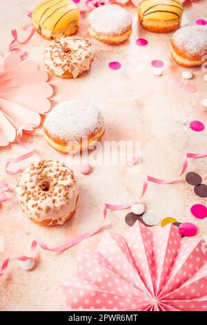 Traditioneller Berliner für Fasching und Party. Deutsch Krapfen oder Donuts mit Streamer und Konfetti. Bunte Karneval oder Geburtstag Bild Stockfoto