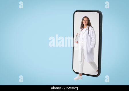 Telemedizinkonzept. Fröhliche Senior-Ärztin in Uniform kommt aus dem großen Handybildschirm, Panorama-Banner Stockfoto