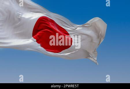 Japanische Nationalflagge, die an klaren Tagen im Wind wehte. Rote Scheibe auf weißem Feld. Japan ist ein Inselland in Ostasien. Realistische 3D-Darstellung. Stockfoto