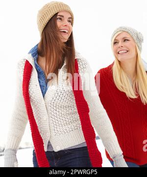 Die Welten waren nicht so kalt, als sie zusammen waren. Zwei Freunde gehen gemeinsam im Schnee spazieren. Stockfoto