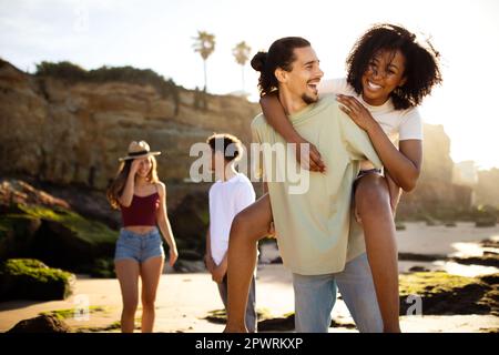 Lächelnde junge, multiethnische Menschen haben Spaß zusammen am Strand, genießen Sie den Ausflug zur freien Verfügung Stockfoto