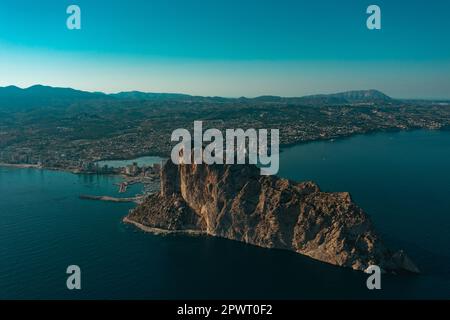 Luftaufnahme atemberaubende Penyal dIfac Naturpark von Penon de Ifach massiven Kalkstein auf dem Mittelmeer, vertäute Schiffe im Hafen von Calpe. Sunn Stockfoto