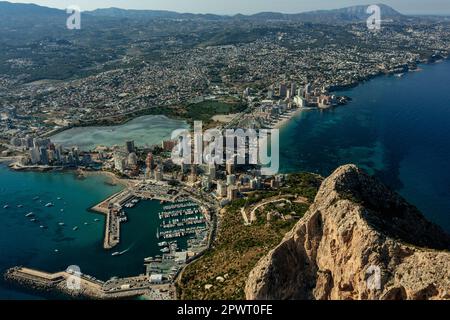 Luftaufnahme atemberaubende Penyal dIfac Naturpark von Penon de Ifach massiven Kalkstein auf dem Mittelmeer, vertäute Schiffe im Hafen von Calpe. Sunn Stockfoto
