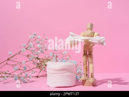 Runde kosmetische Polster aus Baumwolle und Wattestäbchen auf pinkfarbenem Hintergrund Stockfoto