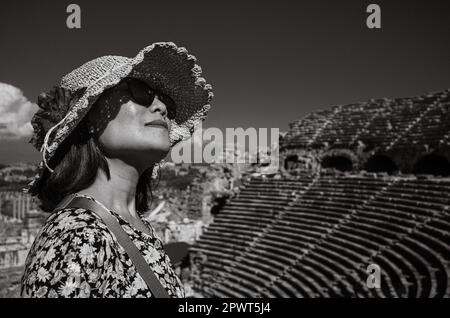 Eine vietnamesische Asiatin mit Hut und Sonnenbrille besucht das große und gut erhaltene römische Amphitheater in Side in der Provinz Antalya, Tur Stockfoto