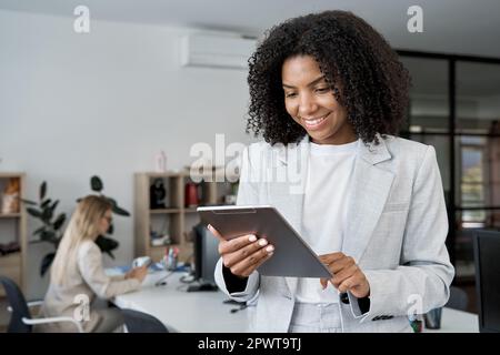 Junge Geschäftsfrau, die in einem modernen Büro mit einem Touchscreen-pc-Tablet arbeitet Stockfoto