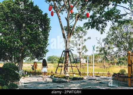 KANCHANABURI -THAILAND, MÄRZ 30 ,2023 : Unbekannte Touristen kommen zu Besuch und machen Fotos mit einem Restaurant und Café mit einem wunderschönen Garten Stockfoto