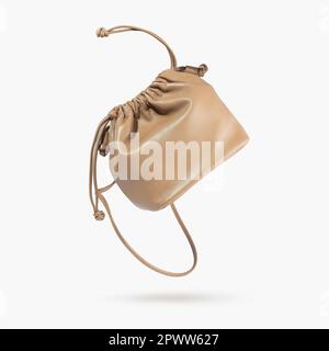 Eine braune weibliche Handtasche mit Trägern auf grauem Hintergrund. Minimalistisches Layout mit Tasche. Werbung für Ladys, Blog. Trendige Accessoires Stockfoto