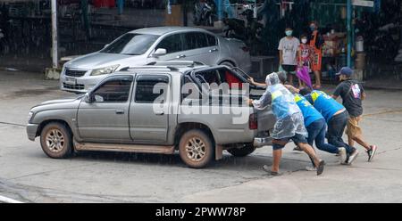 Männer helfen, ein beschädigtes Auto auf die Straße zu schieben, Bangkok, Thailand Stockfoto