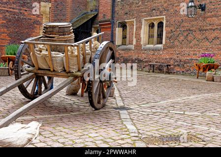 Ein alter, von Pferden gezogener Holzkarren mit einem Weinfass im Ausstellungsstück - englischer traditioneller Hintergrund - Barrel on Cart Stockfoto