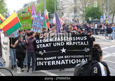 Leipzig, Deutschland. 01. Mai 2023. Teilnehmer einer Demonstration verschiedener linker Gruppen gehen mit Bannern und Flaggen auf einer Straße entlang. Mehr als 1000 Menschen nahmen an einer kapitalismuskritischen Demonstration Teil. Kredit: Sebastian Willnow/dpa/Alamy Live News Stockfoto