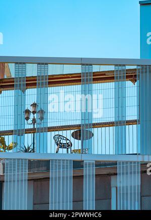 Details der Fassade und Struktur eines modernen, avantgardistischen und minimalistischen Gebäudes mit großen rechteckigen blauen Kristallen und einer Terrasse im Stockfoto