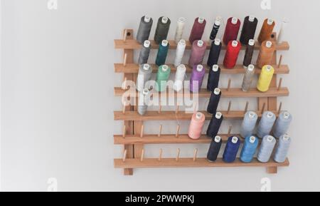 Eine Sammlung von mehrfarbigen Nähfäden, die auf einem hölzernen, wandmontierten Gewinderahmen mit Schieber auf weißem Hintergrund mit Kopierbereich dargestellt werden Stockfoto