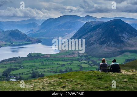 Spaziergänger, die den Blick über Crummock Water und Mellbreak von Loweswater Fell, Lake District, Cumbria bewundern Stockfoto