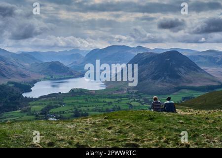 Spaziergänger, die den Blick über Crummock Water und Mellbreak von Loweswater Fell, Lake District, Cumbria bewundern Stockfoto