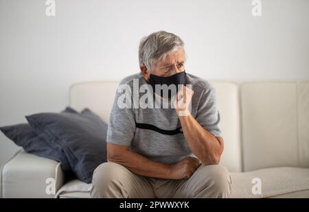 Älterer Mann mit Gesichtsbedeckung während des Coronavirus- und Grippeausbruchs. Schutz vor Viren und Krankheiten, Quarantäne zu Hause. COVID-19 Konzept Stockfoto