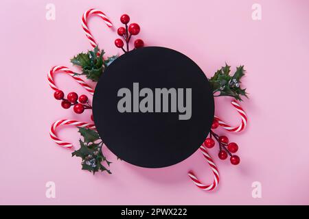 Weihnachtskomposition mit einer Kreidetafel in der Mitte auf pinkfarbenem Hintergrund. Modell Stockfoto