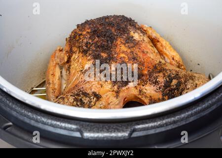 Hähnchen mit Kräutermischungen, in einer Airfryer gekocht. Gesundes, kostengünstiges Kochkonzept Stockfoto