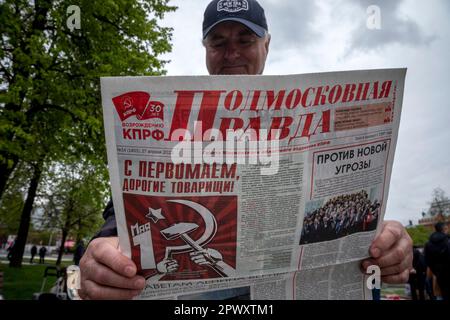 Moskau, Russland. 1. Mai 2023. Ein Mann las die Zeitung Podmoskovnaya pravda während der Rallye der russischen Kommunistischen Partei anlässlich des Labor Day, auch bekannt als Mai Day, am Denkmal des deutschen Philosophen Karl Marx aus dem 19. Jahrhundert in der Nähe des Roten Platzes in Moskau, Russland. Nikolay Vinokurov/Alamy Live News Stockfoto