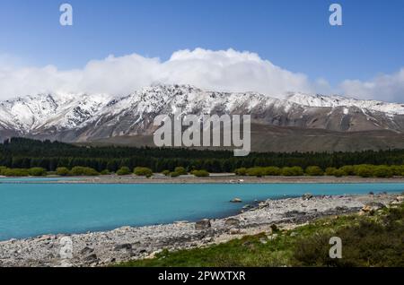 Der Lake Tekapo wird von schneebedeckten Berggipfeln in Neuseeland eingerahmt Stockfoto