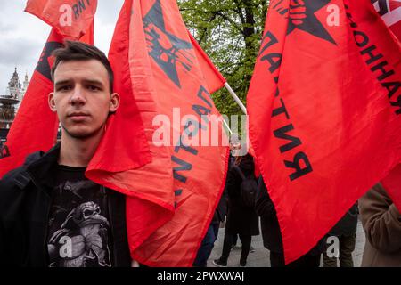 Moskau, Russland. 1. Mai 2023. Ein junger Mann hält die rote Flagge der Revolutionären Arbeiterpartei, während sich andere anlässlich des Labor Day, auch bekannt als May Day, am Denkmal des deutschen Philosophen Karl Marx aus dem 19. Jahrhundert in der Nähe des Roten Platzes in Moskau, Russland, versammeln. Nikolay Vinokurov/Alamy Live News Stockfoto
