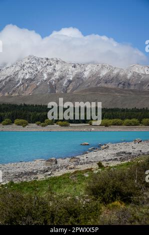 Der Lake Tekapo wird von schneebedeckten Berggipfeln in Neuseeland eingerahmt Stockfoto