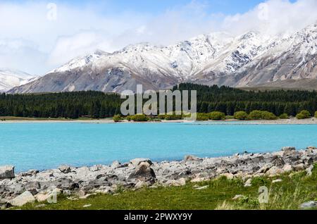 Der Lake Tekapo wird von schneebedeckten Berggipfeln in Neuseeland eingerahmt Stockfoto