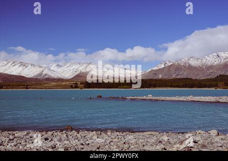 Der Lake Tekapo wird von schneebedeckten Berggipfeln in Neuseeland eingerahmt Stockfoto