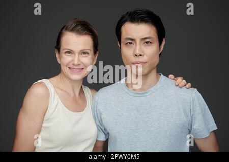 Porträt von Mann und Frau, die sich umarmen und in die Kamera schauen Stockfoto