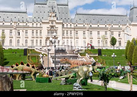 Iasi, Rumänien - 28. April 2023: Dinosaurierpark im Palas Public Garden. Palatul Culturii oder Kulturpalast im Hintergrund Stockfoto