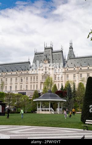 Iasi, Rumänien - 28. April 2023 Palatul Culturii oder der Kulturpalast ist ein Gebäude in Iași, Rumänien. Kinder spielen auf dem Rasen vor dem Stockfoto