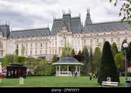 Iasi, Rumänien - 28. April 2023: Palatul Culturii oder der Kulturpalast ist ein Gebäude in Iași, Rumänien. Kinder spielen auf dem Rasen vor o Stockfoto