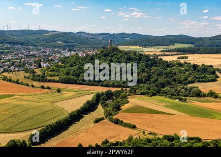 Der Hügel des Höhenburg Vetzbergs auf einem Vulkanberg im Zentrum Hessens, eingebettet in eine landwirtschaftliche Landschaft mit einem leicht bewölkten Himmel am Himmel Stockfoto