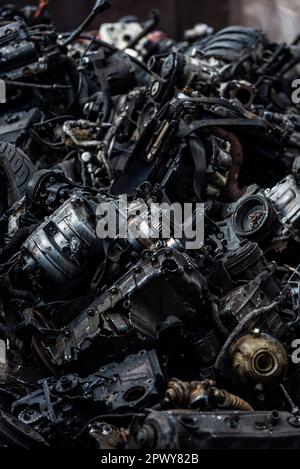 Container mit Motoren und Teilen von Motorrädern und Autos, die als Altmetall zum Recycling aufgestapelt werden Stockfoto